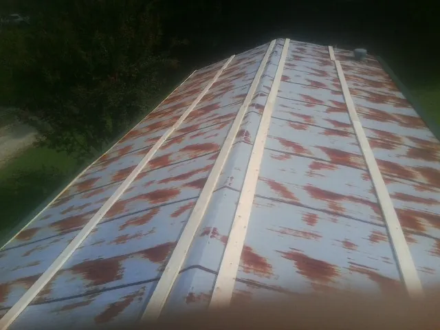 Rusted metal roof panels with new wood purlins before replacement — Storm Damage Roof Repair in Prairie Du Sac by Roofing Brothers
