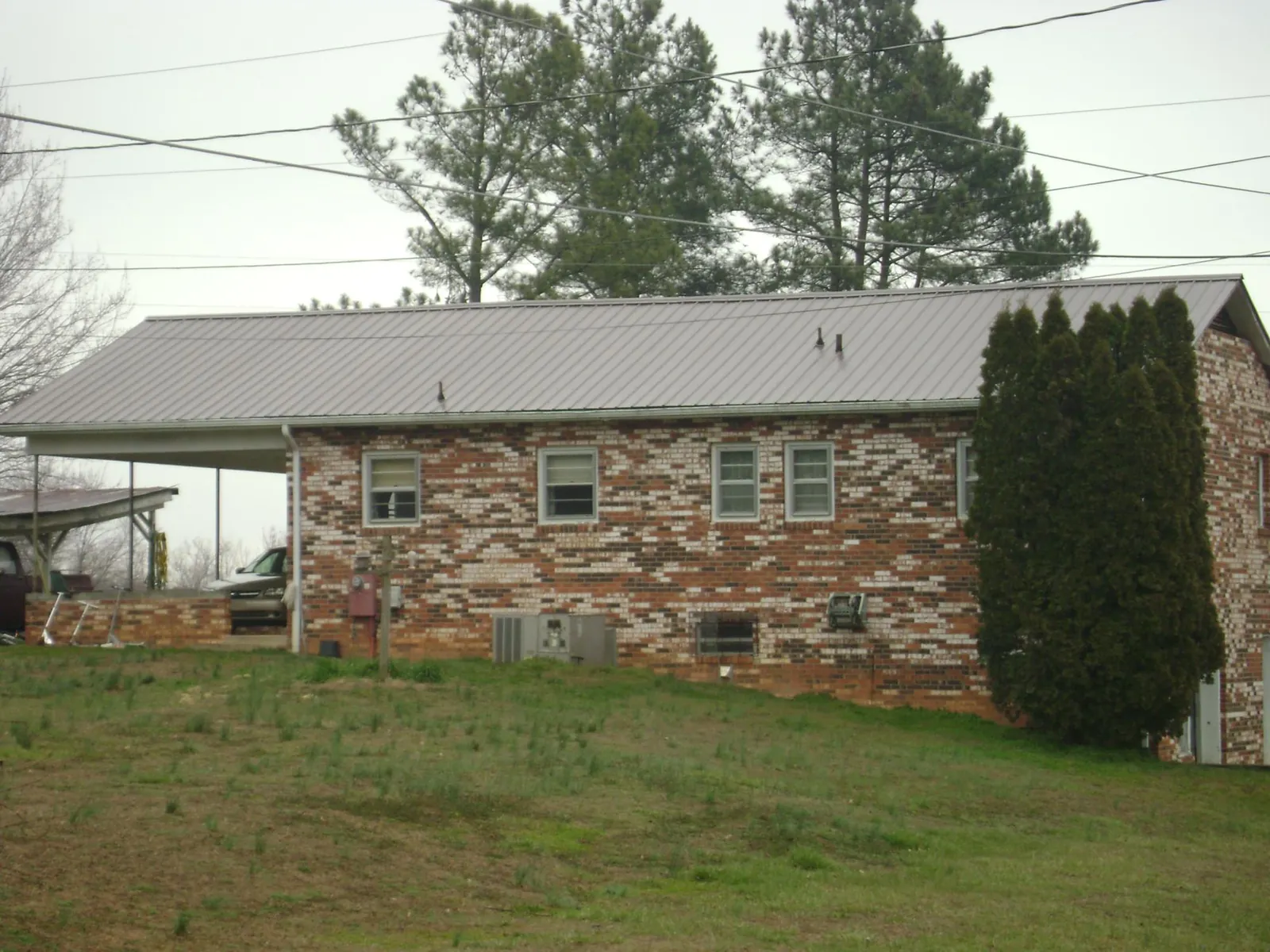 Gray metal roof on a brick split level home with a carport in Prairie Du Sac