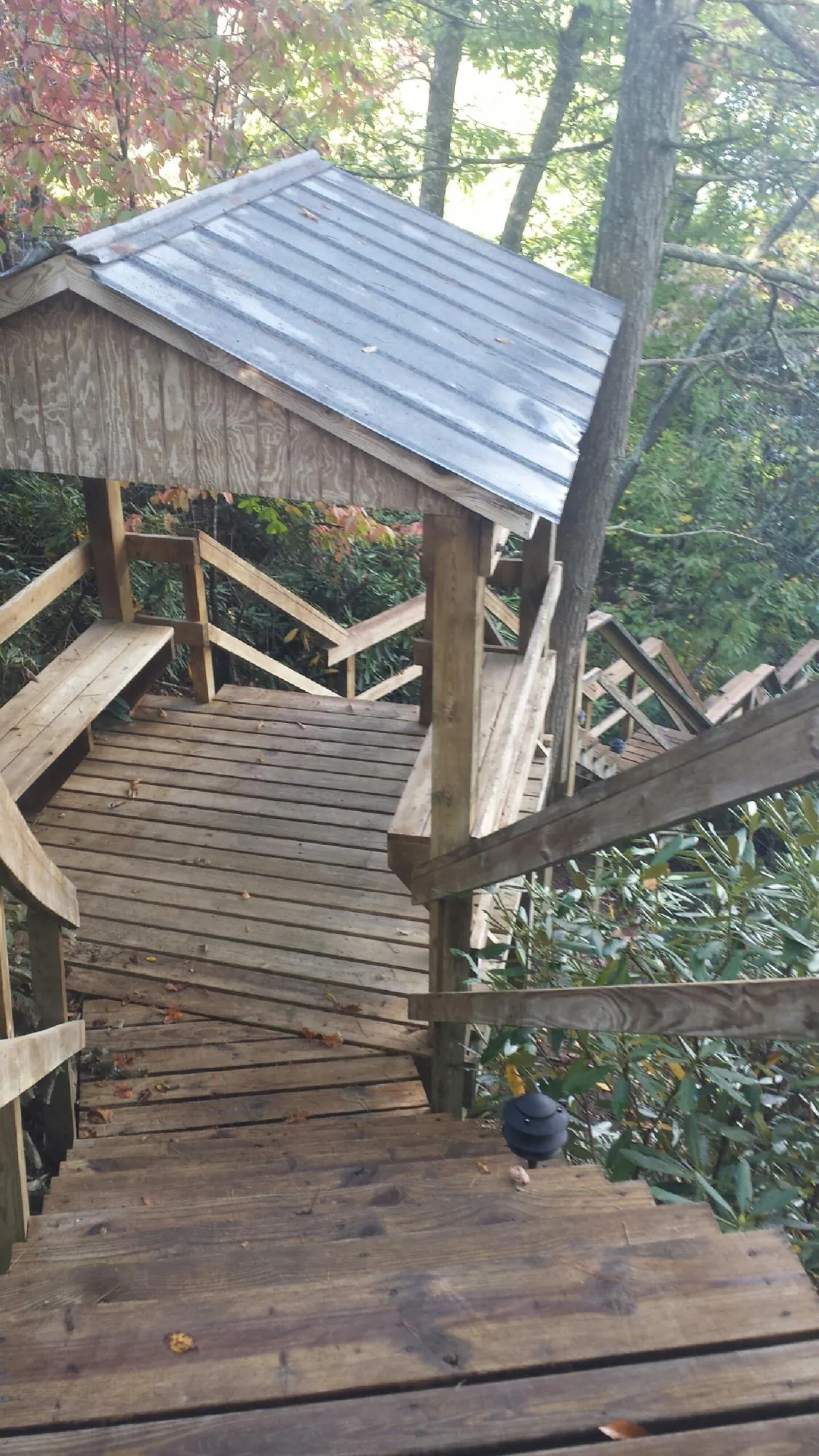 Metal roofed shelter over wooden steps on a wooded walkway — Skylight Repair & Installation work by our crew in Prairie Du Sac