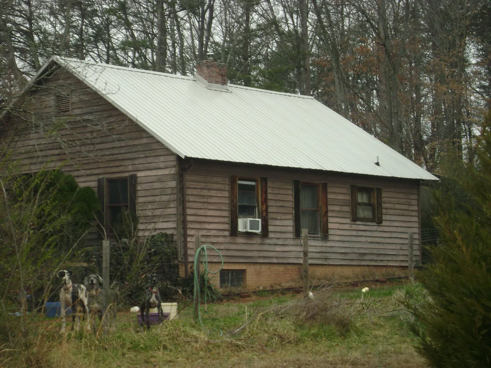 White metal roof on an old wood sided farmhouse, from a Asphalt Shingle Roof Repair job in Prairie Du Sac